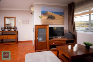 a living room with a television and a table at Tita Apartment Montaña La Data in San Bartolomé