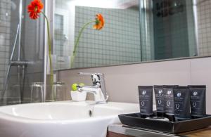 ein Badezimmer mit Waschbecken und Spiegel in der Unterkunft Leonardo Boutique Hotel Barcelona Sagrada Familia in Barcelona