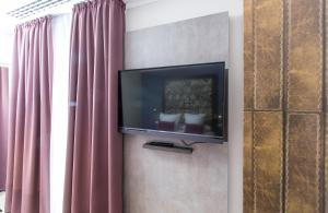 una TV a schermo piatto su un muro accanto a una finestra di Leonardo Boutique Hotel Barcelona Sagrada Familia a Barcellona