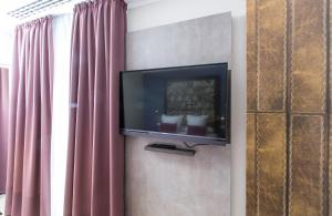 einen Flachbild-TV an einer Wand neben einem Fenster in der Unterkunft Leonardo Boutique Hotel Barcelona Sagrada Familia in Barcelona