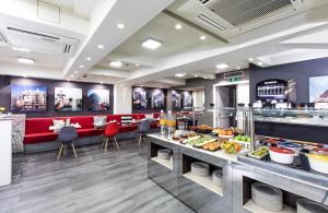 ein Restaurant mit einem Buffet mit ausgestellten Speisen in der Unterkunft Leonardo Boutique Hotel Barcelona Sagrada Familia in Barcelona