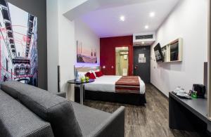 ein Hotelzimmer mit einem Bett und einer Couch in der Unterkunft Leonardo Boutique Hotel Barcelona Sagrada Familia in Barcelona