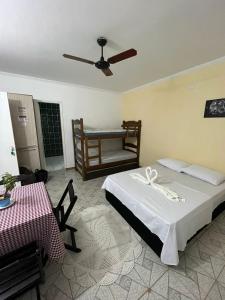 a bedroom with a bed and a table and a fan at Pousada das Estrelas in São Pedro