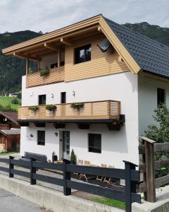 une maison blanche avec un toit en bois dans l'établissement Landhaus Klara, à Neustift im Stubaital