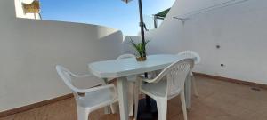 uma mesa branca e cadeiras numa varanda em Visconde de Estoi em Faro