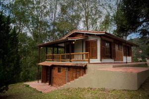 ein kleines Haus mit einer Veranda und einem Balkon in der Unterkunft Embaúba Boutique Hotel in Teresópolis