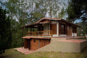 uma pequena casa com um alpendre e uma varanda em Embaúba Boutique Hotel em Teresópolis