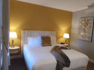 sypialnia z dużym białym łóżkiem z 2 lampami w obiekcie The Lancefield Lodge w mieście Lance Field