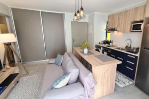uma sala de estar com um sofá e uma cozinha em Hitivai apartment em Papeete