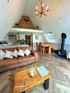 a living room with a couch and a table at Bonnie Lodge-Lochside Location with Hot Tub in Invergarry
