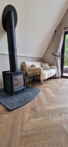 a living room with a wood stove in a room at Bonnie Lodge-Lochside Location with Hot Tub in Invergarry