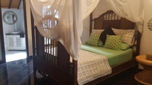a bedroom with a bed with a canopy at Villa Jati - Private Poolside Villa Central Lovina in Lovina