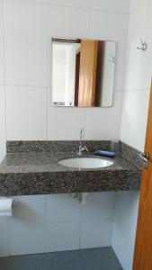 a bathroom counter with a sink and a mirror at Residencial Marbella in Bombinhas +33 photos