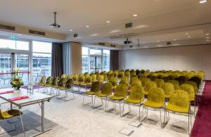 una sala conferenze con sedie e tavoli gialli di Leonardo Royal Hotel Venice Mestre a Mestre