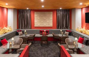 un restaurant avec des murs rouges, des tables et des chaises dans l'établissement Leonardo Royal Hotel Venice Mestre, à Mestre