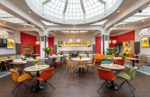 a restaurant with tables and chairs and a large skylight at NYX Hotel Prague by Leonardo Hotels in Prague