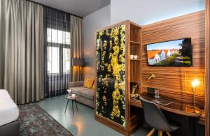 a hotel room with a desk and a bed and a room at NYX Hotel Prague by Leonardo Hotels in Prague