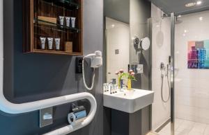 a bathroom with a sink and a shower at NYX Hotel Prague by Leonardo Hotels in Prague