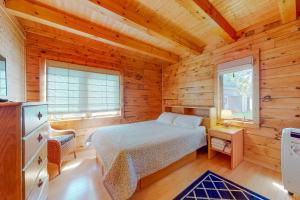 ein Schlafzimmer mit einem Bett in einer Holzhütte in der Unterkunft Kismet in North Hero