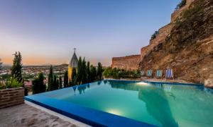 a large swimming pool in front of a mountain at Castle in Old Town in Tbilisi City