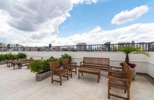 a patio with benches and tables on a roof at SAMPA apartamento inteiro, Completo e Confortável in Sao Paulo