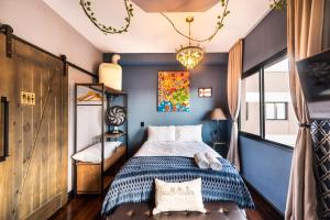 Schlafzimmer mit einem Bett mit blauen Wänden und einem Kronleuchter in der Unterkunft SAMPA apartamento inteiro, Completo e Confortável in São Paulo