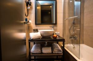 a bathroom with a sink and a shower and a tub at NYX Hotel Madrid by Leonardo Hotels in Madrid