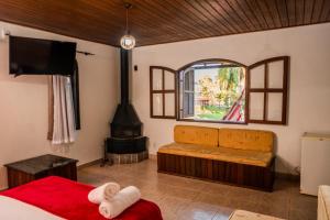 a room with a fireplace and a bed and a stove at Pousada Tapera in Penedo +137 photos