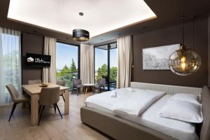 1 dormitorio con 1 cama, mesa y sillas en Hill Apartments en Požarevac