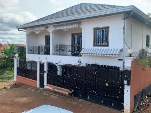 a white house with a black fence at Villa luxueuse - Odza - Yaoundé in Yaoundé