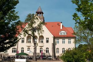 ein großes weißes Gebäude mit rotem Dach in der Unterkunft Schloss Krugsdorf in Krugsdorf