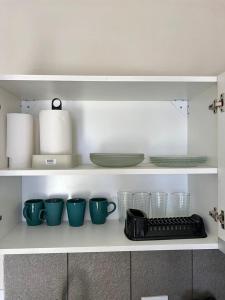 estante de cocina con tazas y platos y teclado en Apart Juncal en Corrientes