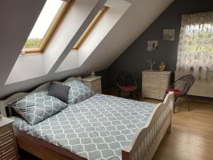 a bedroom with a bed and two chairs in a attic at 4 Bedroom family house with access to a hot tub in Goczałkowice-Zdrój