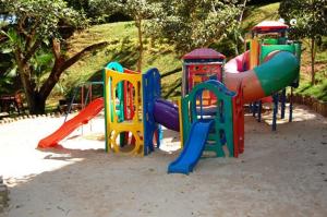 a playground with colorful play equipment in a park at Thermas Paradise Apart in Rio Quente