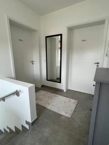 ein Badezimmer mit zwei weißen Türen und einem Spiegel in der Unterkunft Studio - Apartment Steinmetz mit Balkon in Reken
