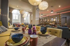 a dining room with a table and chairs and chandeliers at Leonardo Hotel Barcelona Las Ramblas in Barcelona