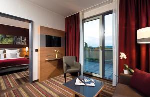 Habitación de hotel con cama y escritorio en Leonardo Hotel Völklingen-Saarbrücken en Völklingen