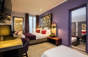 a hotel room with a large bed and a desk at Leonardo Hotel Barcelona Las Ramblas in Barcelona