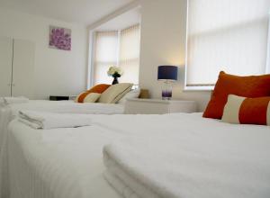 two large white beds in a white room at Remarkable 2-Bed Apartment in Chelmsford in Chelmsford