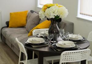 una mesa con platos y un jarrón de flores. en Remarkable 2-Bed Apartment in Chelmsford, en Chelmsford