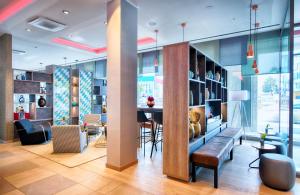 - un hall d'un immeuble avec une table et des chaises dans l'établissement Leonardo Hotel Munich City South, à Munich