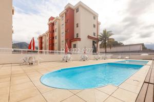 une piscine sur le toit d'un immeuble dans l'établissement Sun Way Apartamentos com piscinas e churrasqueiras, à Ubatuba