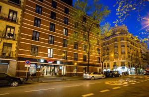 a city street with cars parked in front of buildings at Leonardo Boutique Hotel Madrid in Madrid