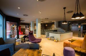 Leonardo Boutique Hotel Madrid في مدريد: غرفة معيشة مع شخص يجلس على أريكة