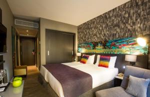 um quarto de hotel com uma cama grande e um sofá em Leonardo Boutique Hotel Madrid em Madrid
