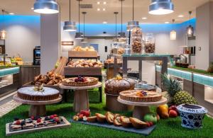 a bakery with many different types of food on display at NYX Hotel Milan by Leonardo Hotels in Milan