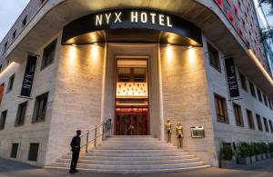 a man standing in front of a myx hotel at NYX Hotel Milan by Leonardo Hotels in Milan