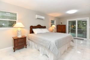 a bedroom with a bed and two lamps and a window at Tropical Hideaway in Port Orange
