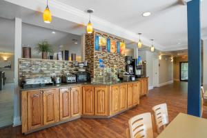a kitchen with wooden cabinets and a brick wall at Best Western Wakulla Inn & Suites in Crawfordville