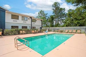 una piscina con sillas y un edificio en Best Western Wakulla Inn & Suites, en Crawfordville